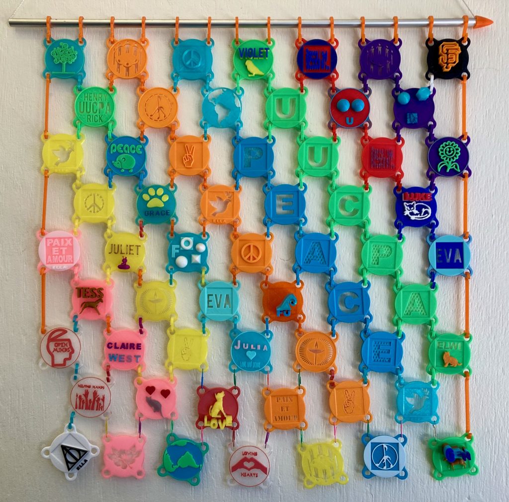 Colorful 3d printed peace symbols made into a wall hanging.