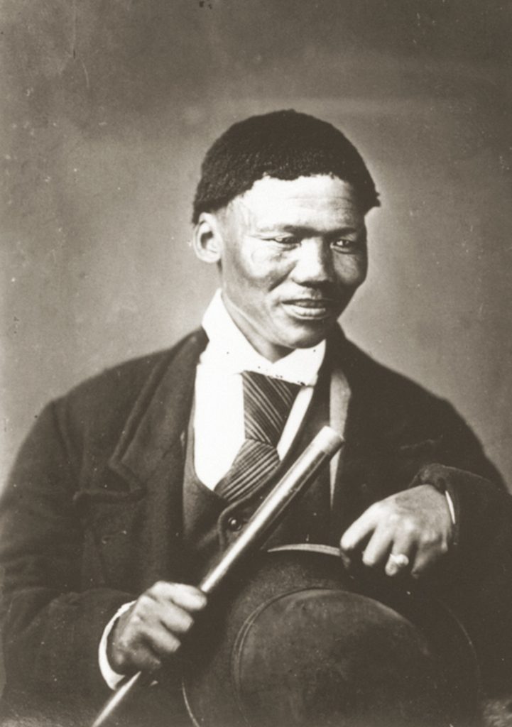 A man in nineteenth century Western clothing, seated for a formal photograph.