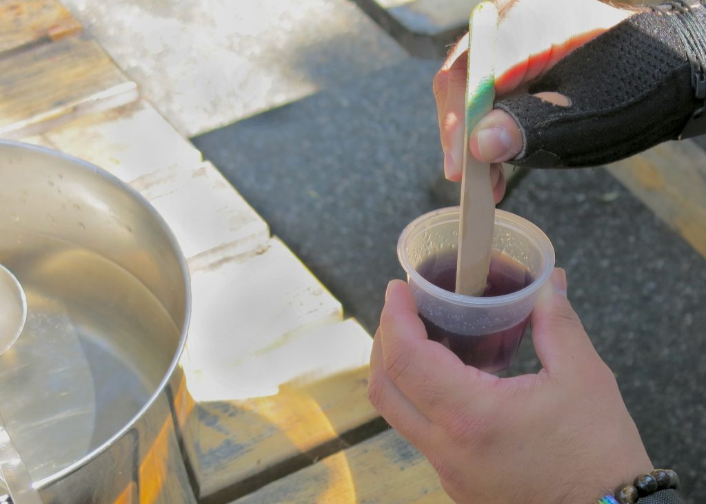 Someone mixing a thick liquid in a small container.