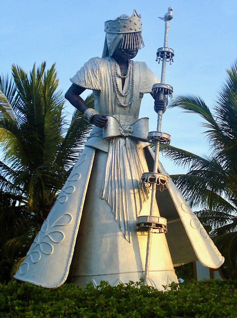 A large statue of a human-looking figure holding a scepter.