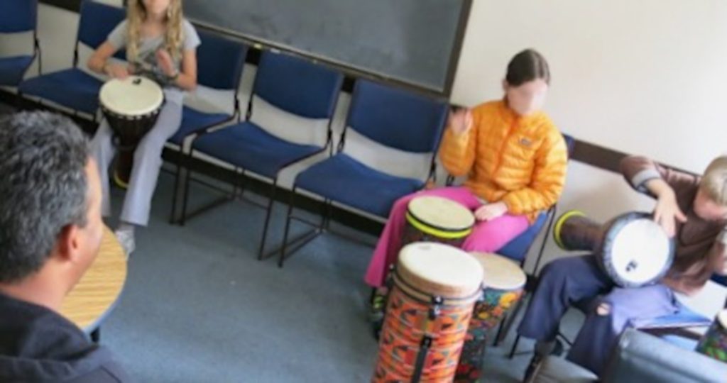 3 children and one adult with drums.