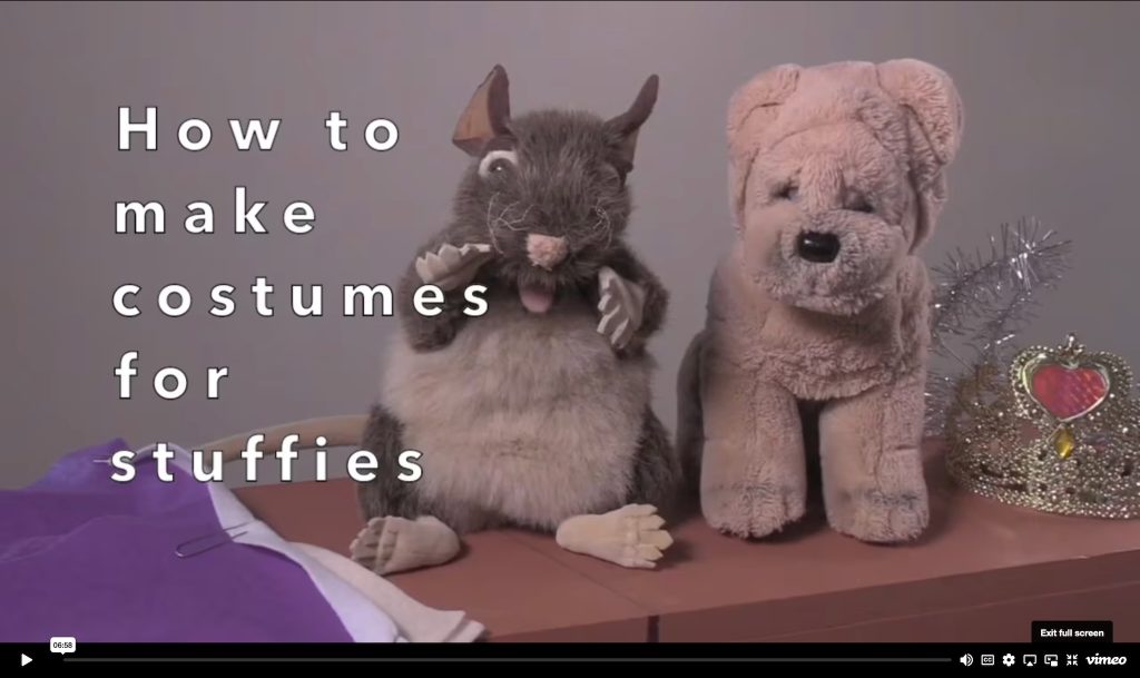 Screenshot from the video showing two toy stuffed animals with materials for making costumes.